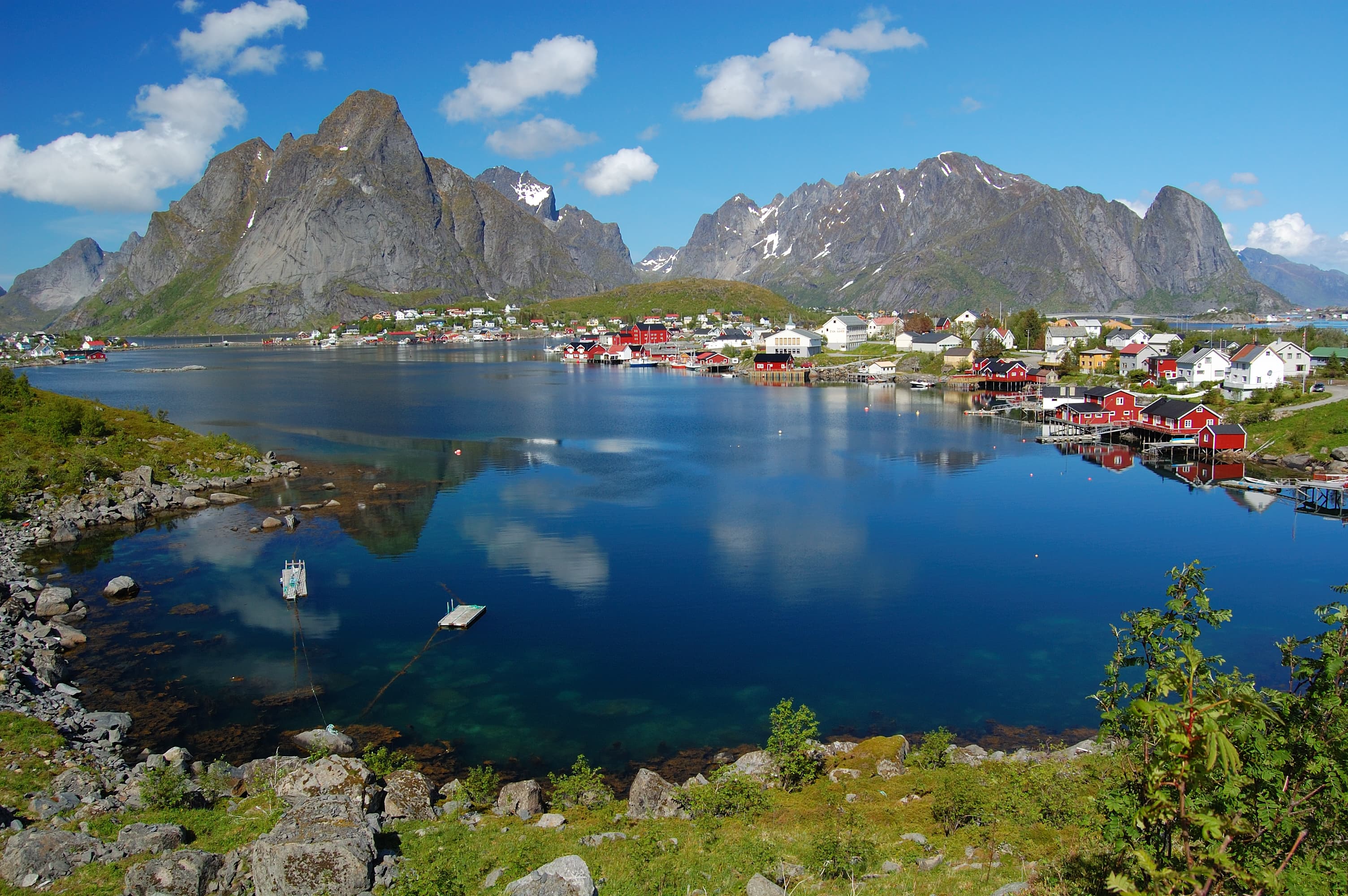 Reine in Lofoten with fishing cabins and mountains reflected in the water